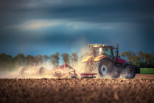 Mietkauf-3 Bauer in seinem geleasten Traktor (Mietkauf) bereitet sein Feld auf