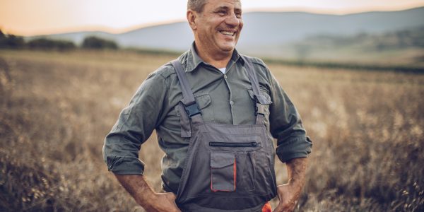 Landwirt steht selbstbewusst auf seinem Feld