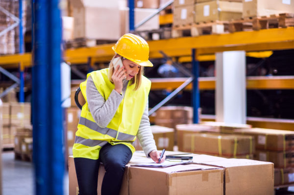 Transport und Logistik-2 Telefonierende Frau, die Waren- und Logistikfinanzierung beansprucht.