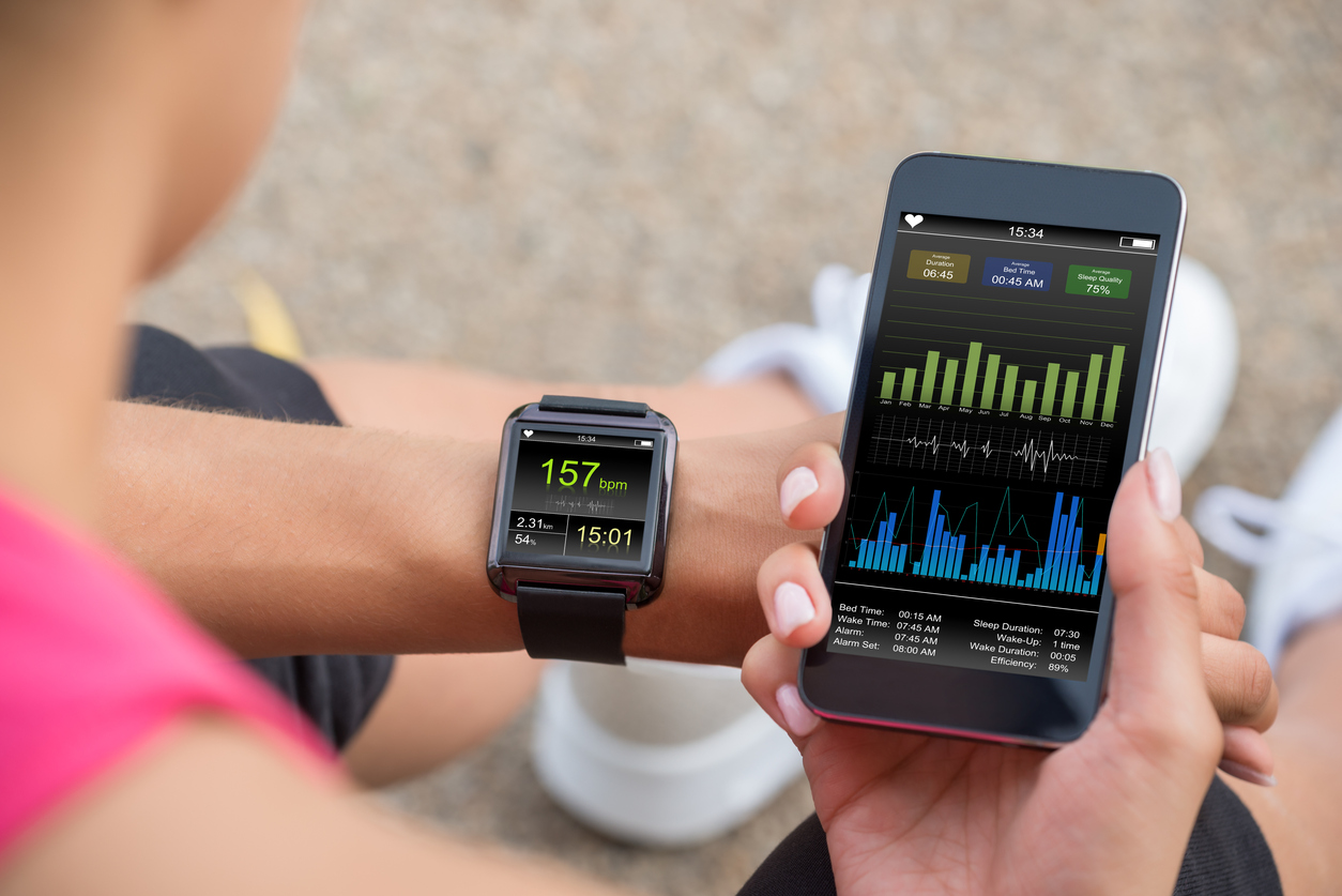 Digitalisierung der Fitnessbranche Smart Watch und Smartphone zum Tracken der Fitnessleistung.