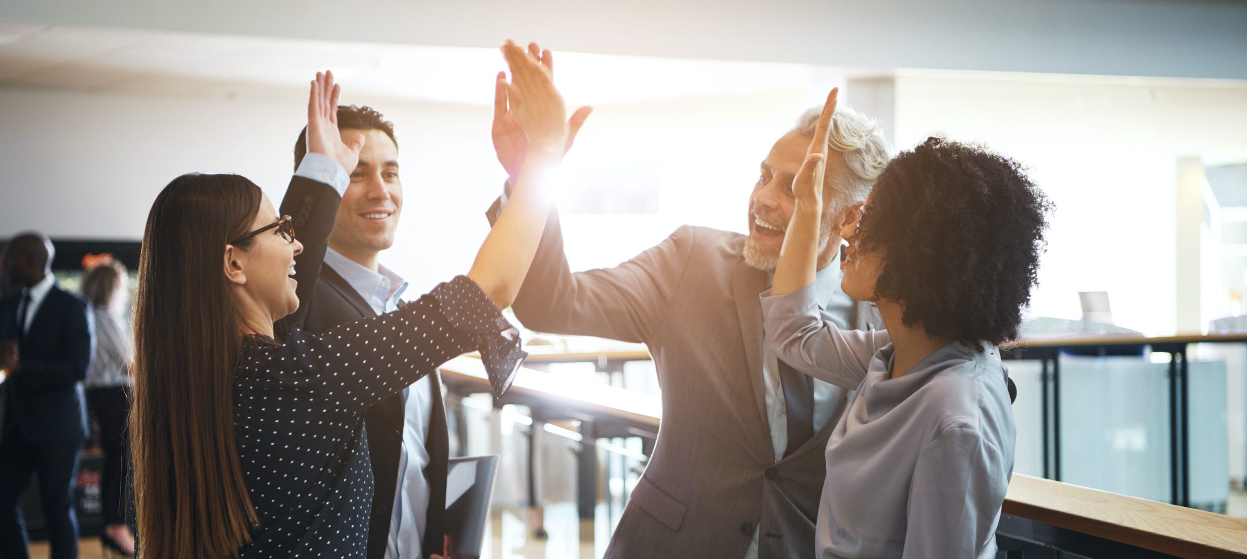 Unternehmerischer Erfolg Lächelnde Kollegen geben sich hi five, um sich für Ihren Erfolg zu beglückwünschen.