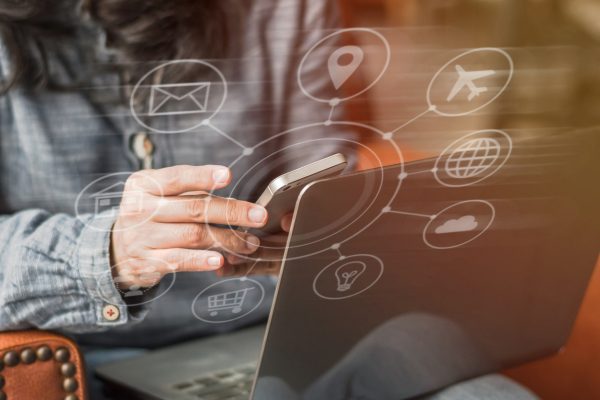 Person am Laptop mit schwebendem IoT Icon Person am Laptop mit schwebendem IoT Icon